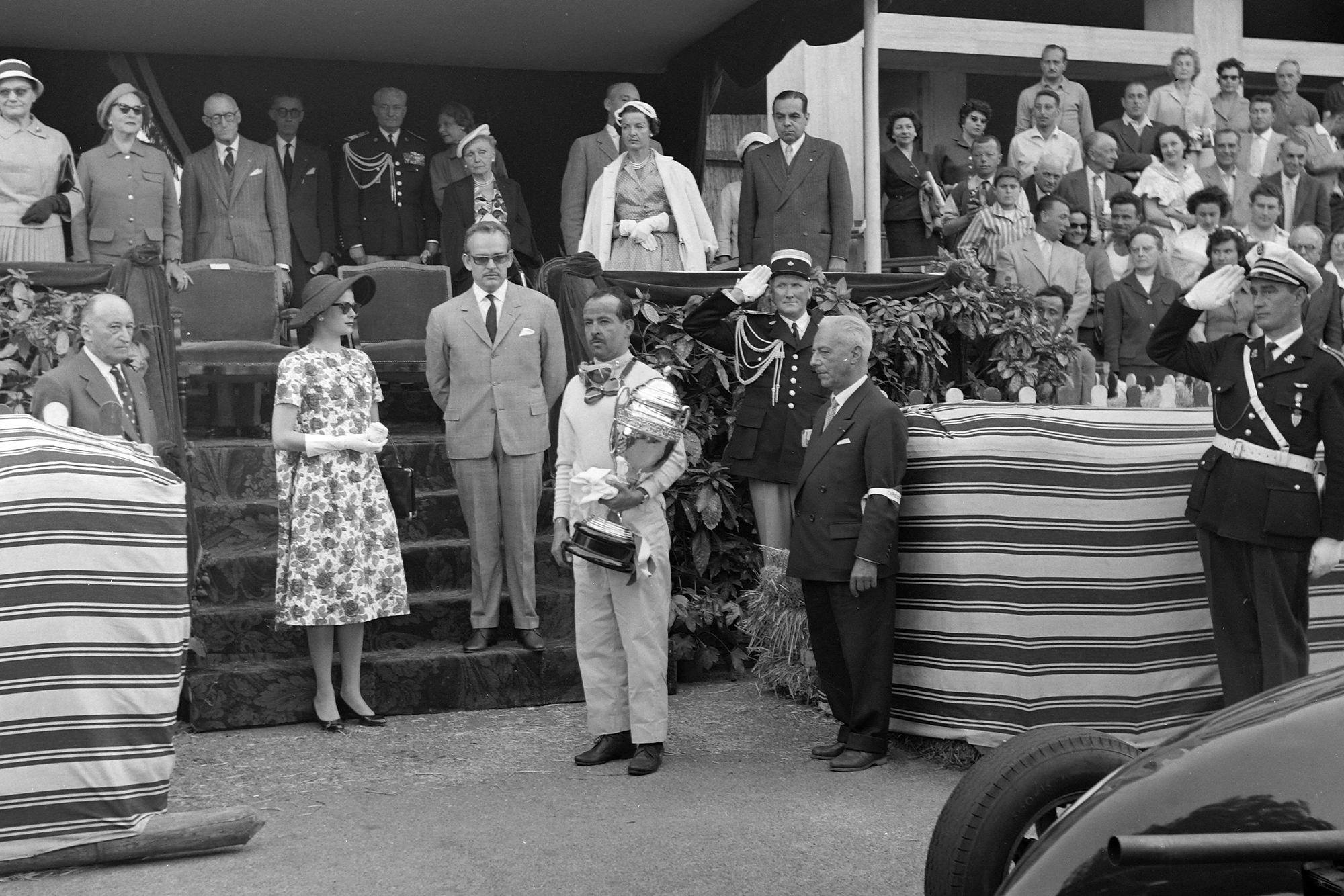 Maurice Trintignant receives his trophy from Prince Rainier and Princess Grace at the 1958 Monaco Grand Prix.