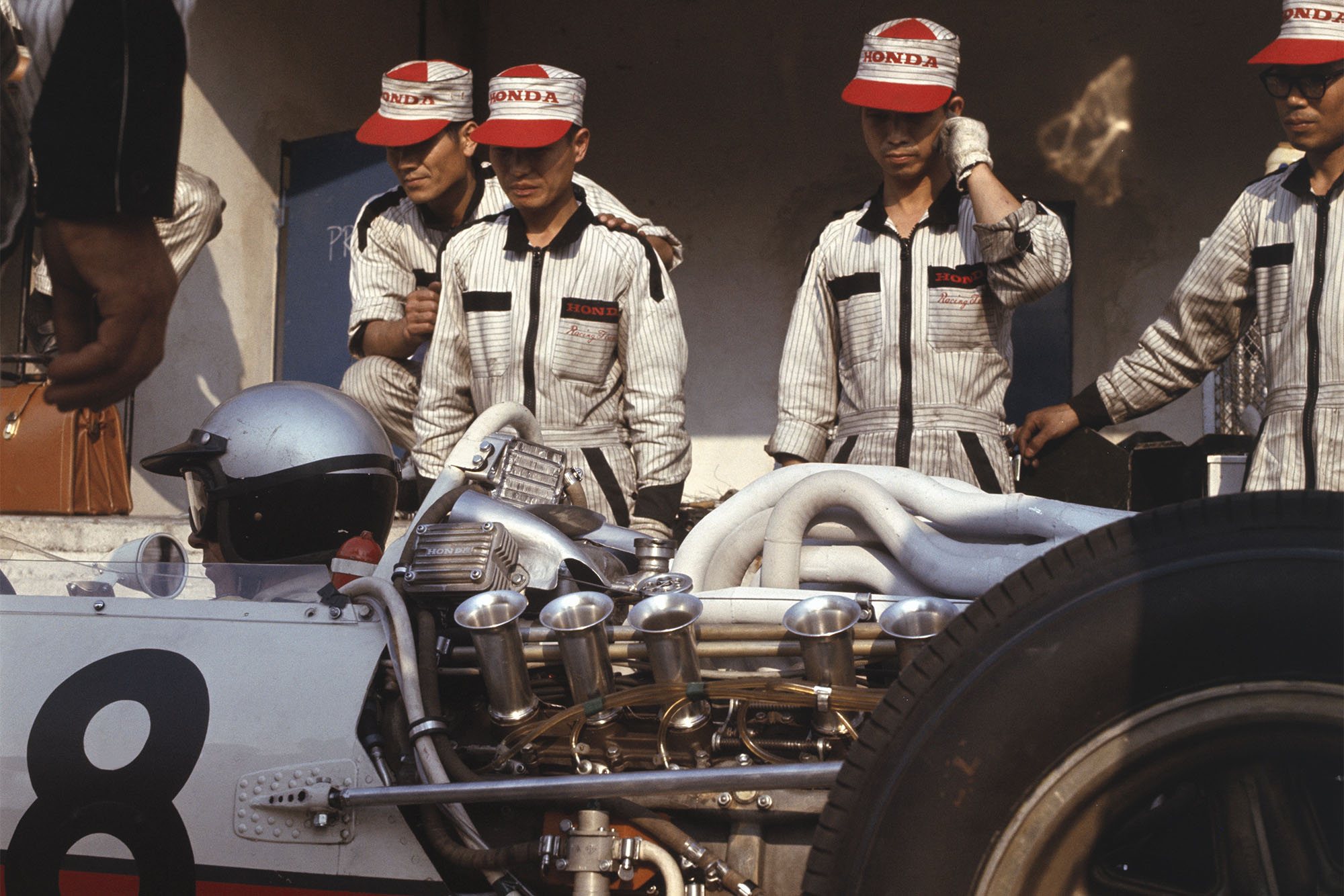 Richie Ginther (Honda RA273) is discussed by the mechanics.