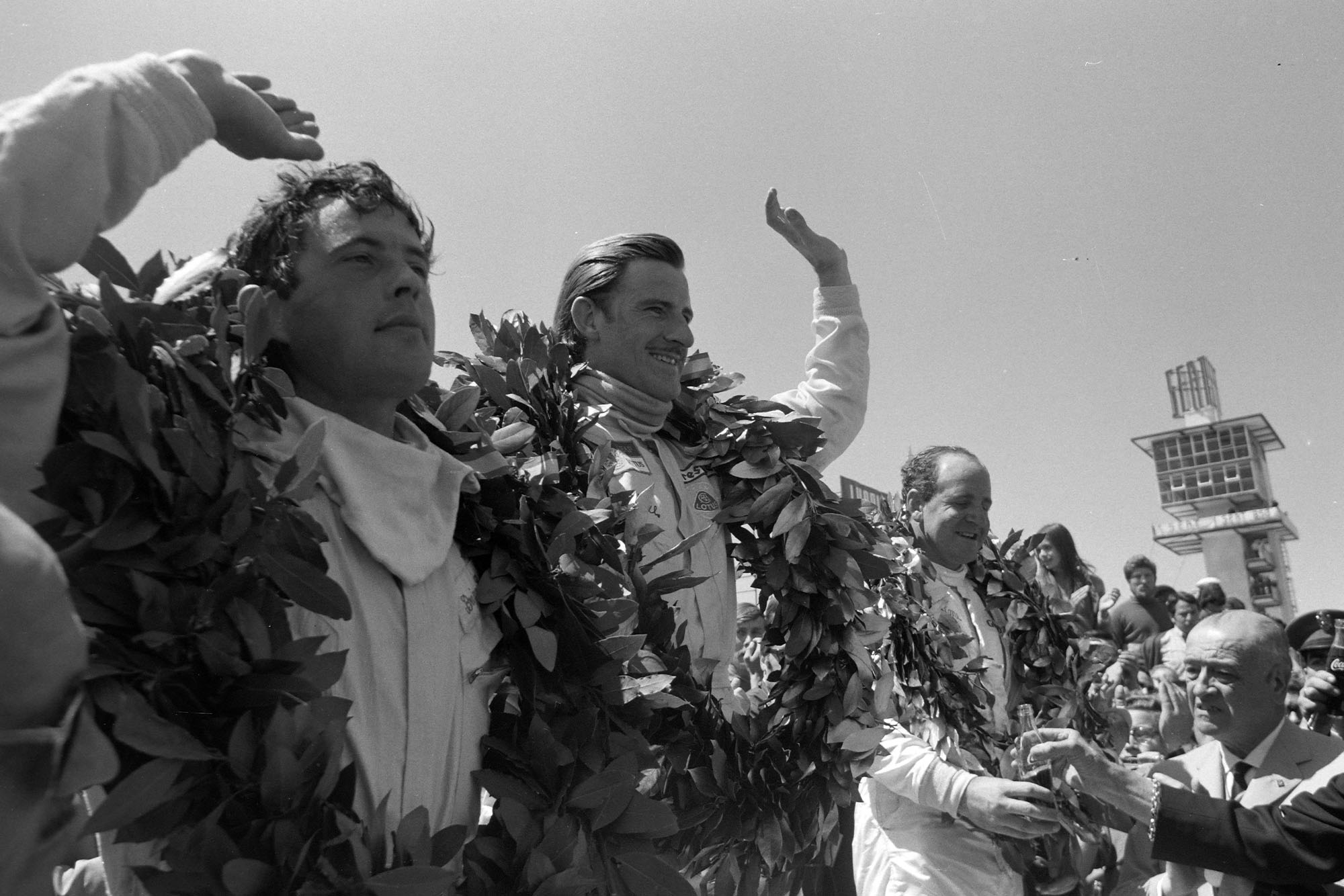Graham Hill, 1st position, on the victory lap with Denny Hulme, 2nd position, and Brian Redman, 3rd position.