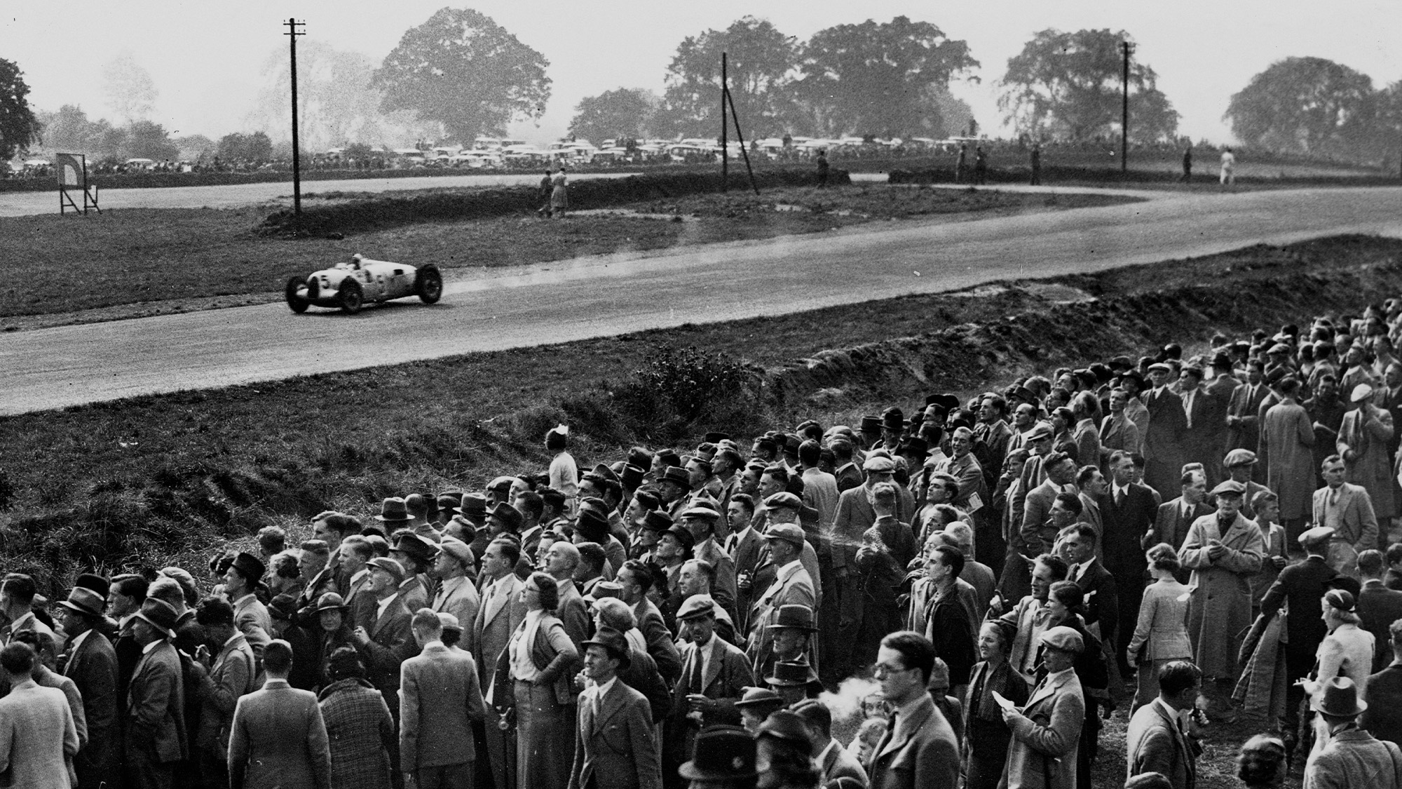 Bernd Rosemeyer drives past crowds of fans in his Auto Union at the 1937 Donington Grand Prix