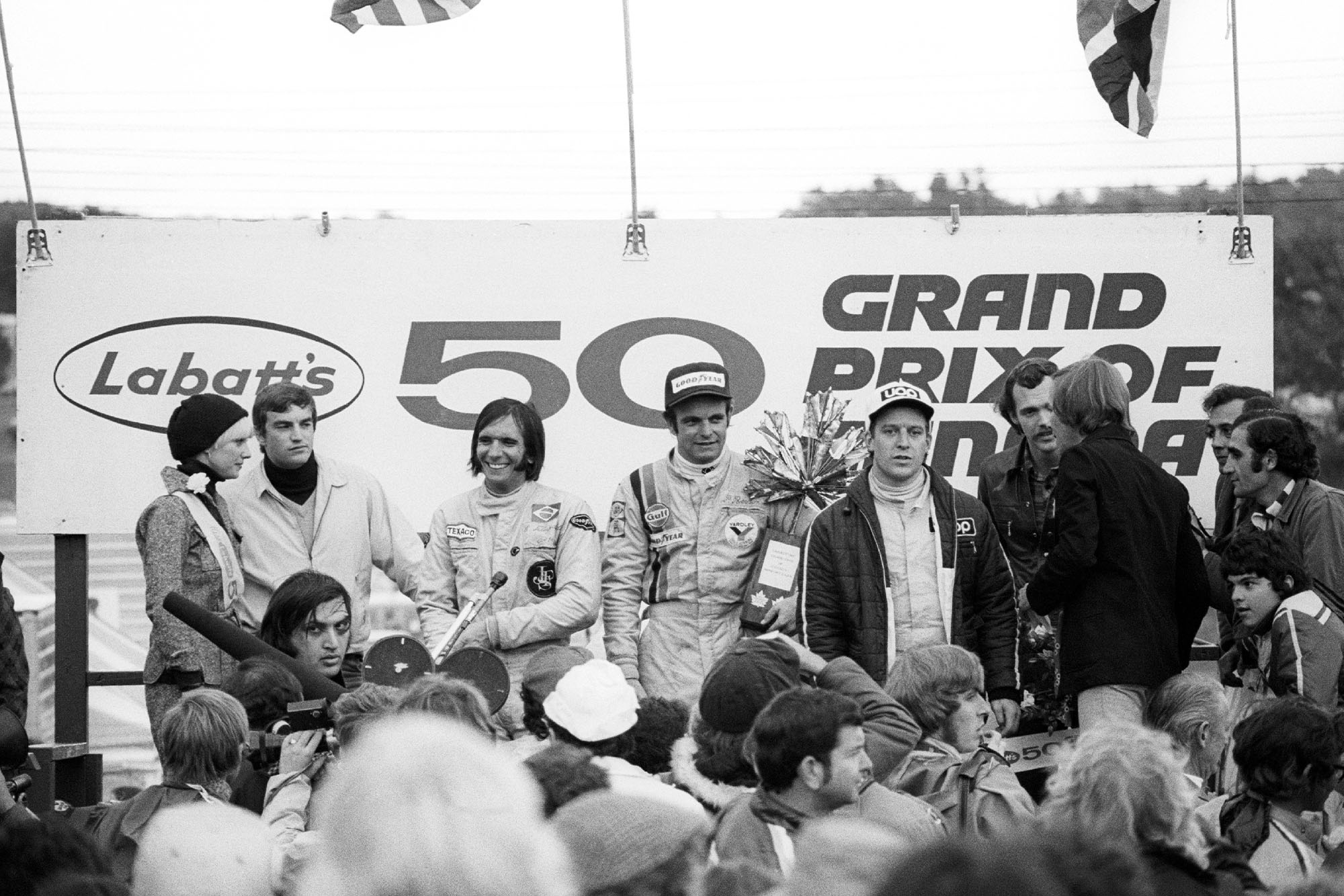 Peter Revson (McLaren) celebrates on the podium afer winning the 2973 Canadian Grand Prix, Mosport Park.