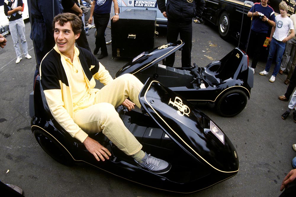 Ayrton Senna Lotus familiarises himself with a JPS liveried Sinclair C5 a revolution in automotive engineering!