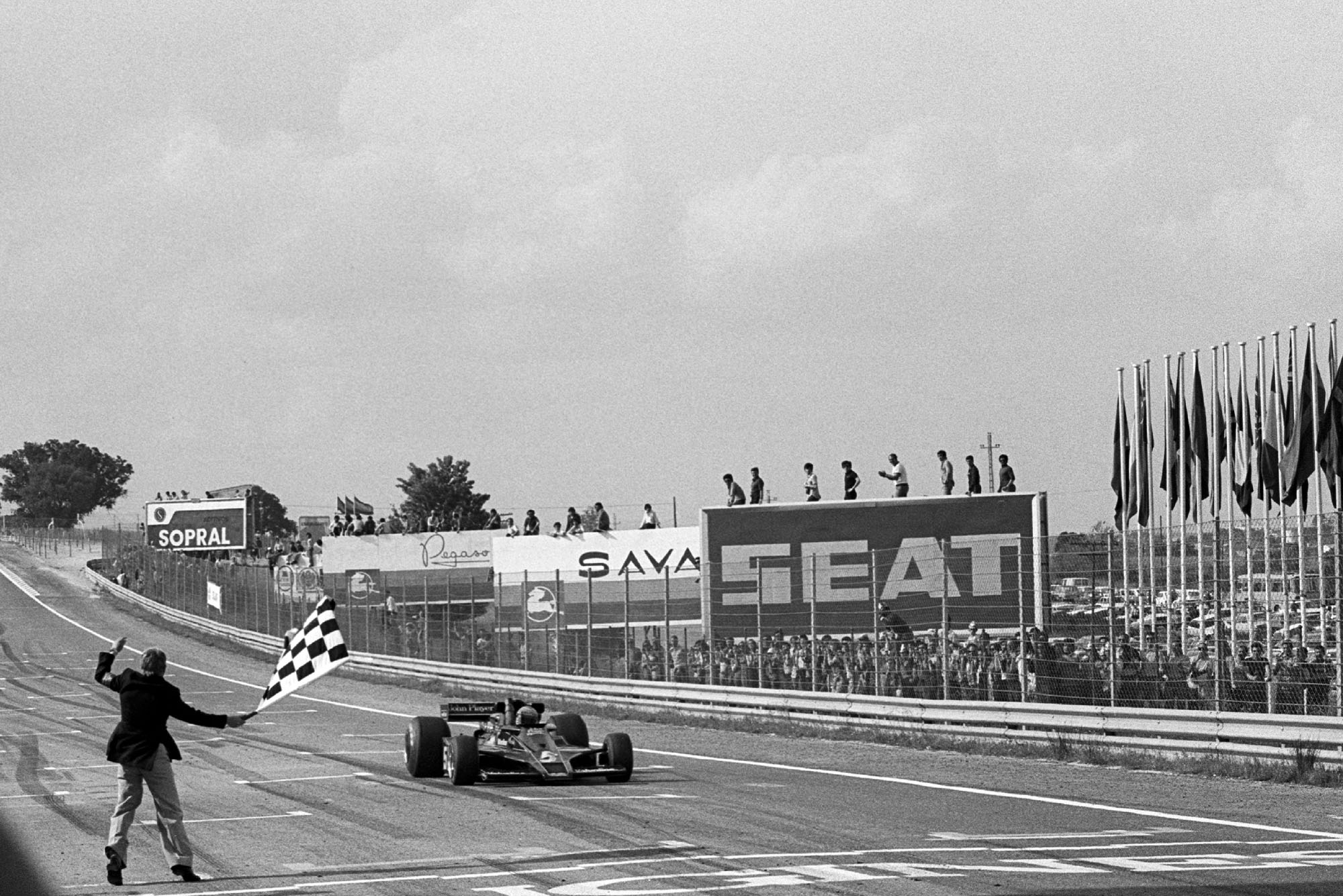Mario Andretti takes the chequered flag ta the 1977 Spanish Grand Prix, Jarama.