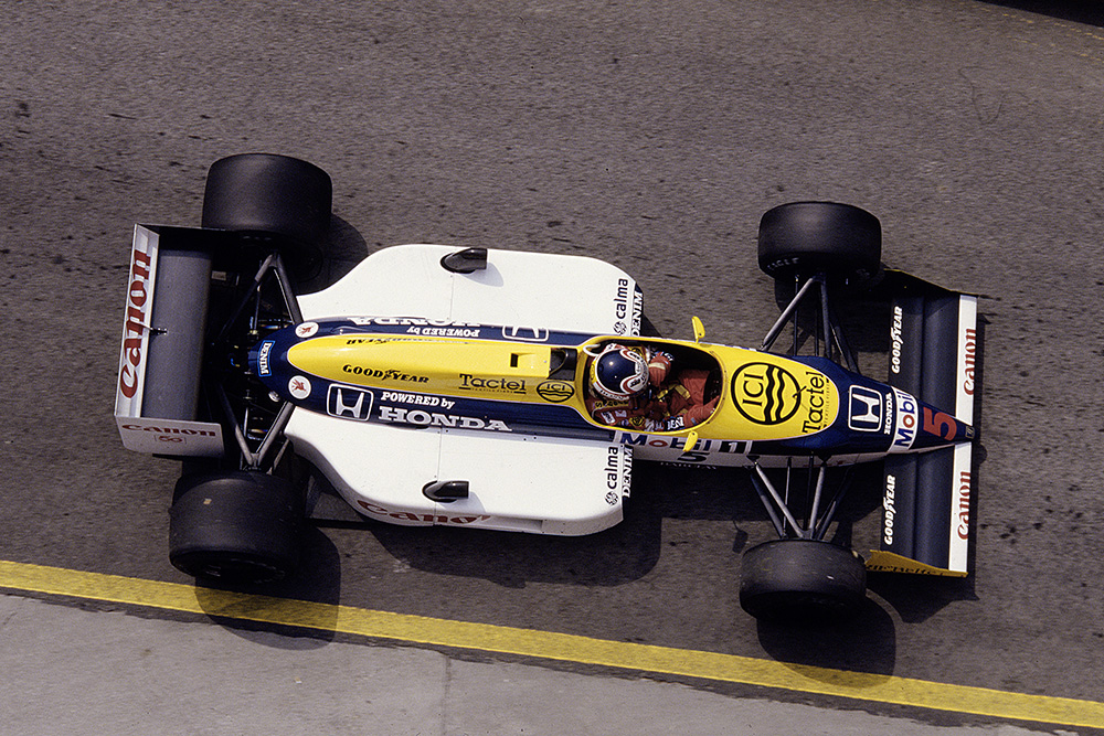 Nigel Mansell driving his Williams FW11B Honda in 1st position.