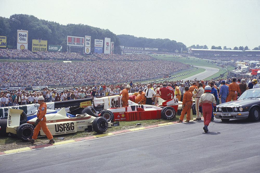 Jacques Laffite is trapped in his Ligier JS27 Renault, after a nine car accident at the start.