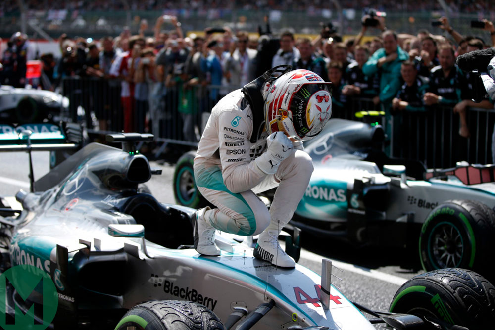 Lewis Hamilton crouches over his Mercedes after winning the 2015 British Grand Pris at Silverstone