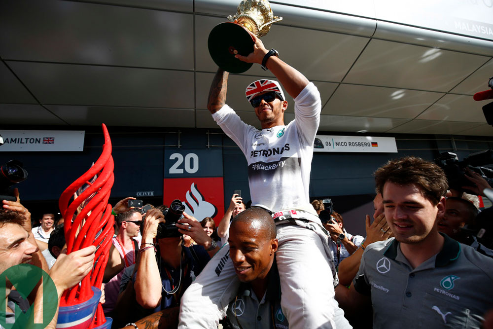 Lewis Hamilton holds the 2014 British Grand prix-winning trophy aloft
