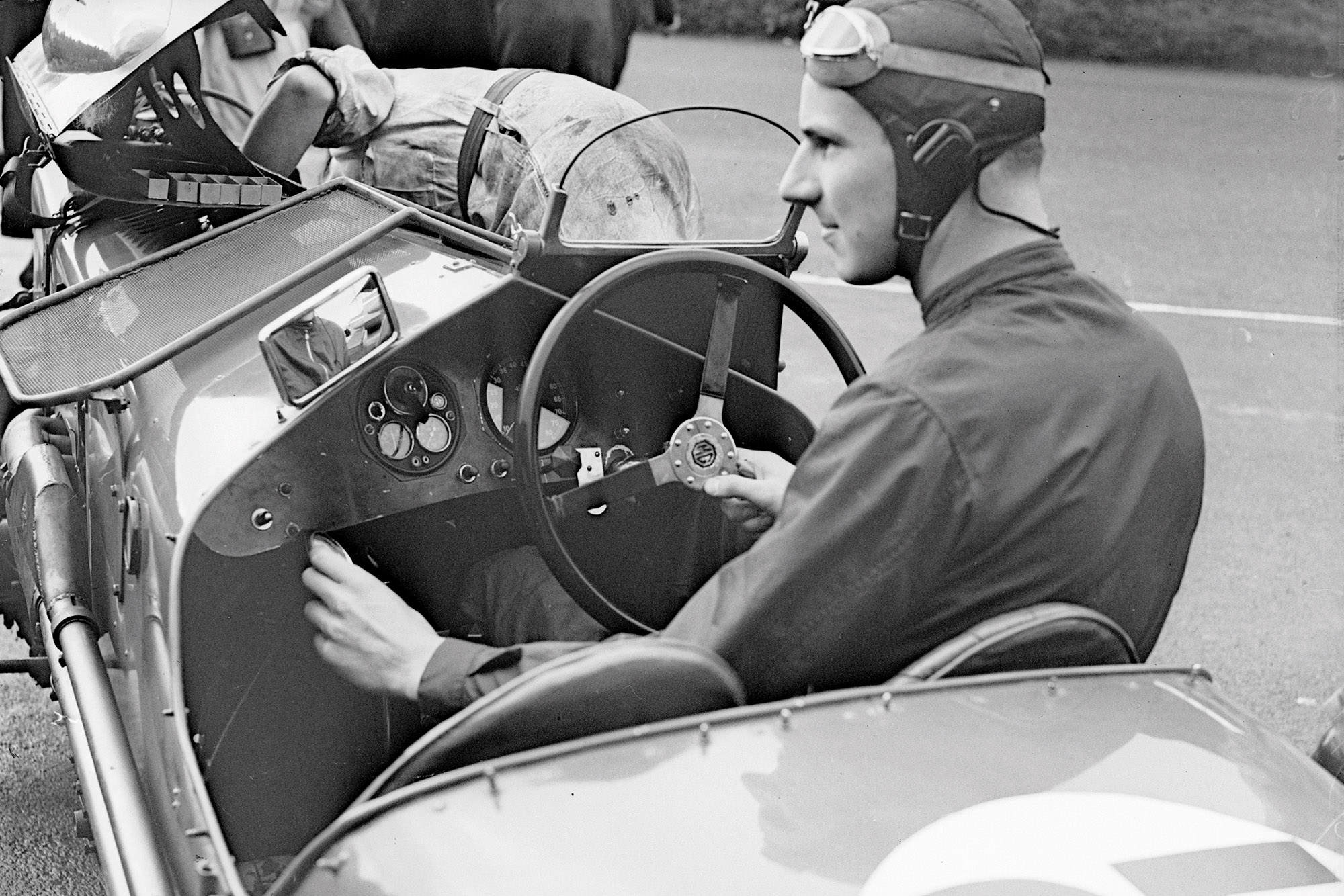 Richard Seaman (1913 - 1939) at the wireless control of an MG car during the Royal Automobile Club Tourist Trophy race practice in Belfast